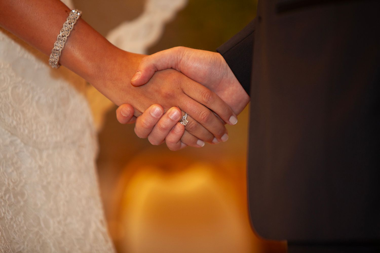 Close-up of hands exchanging wedding rings during an elegant ceremony.