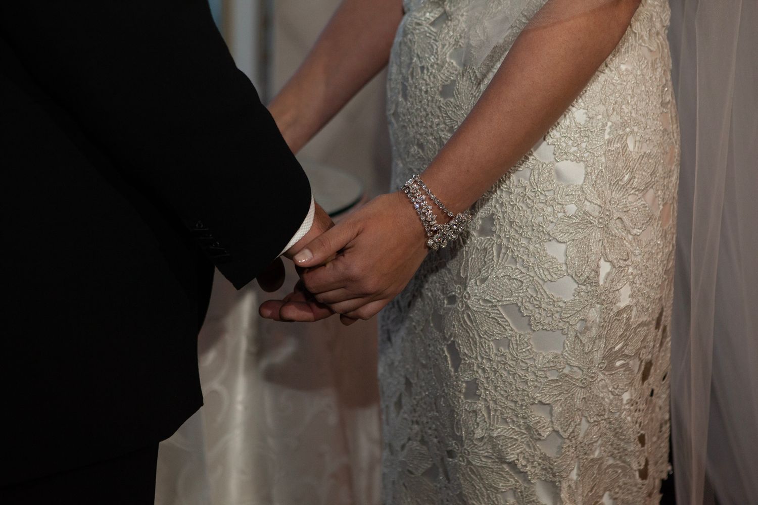 Close-up details of elegant white lace wedding dress and formal attire.