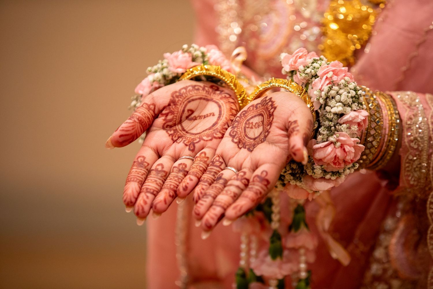 Detailed mehndi artwork displayed on palms with traditional Indian bridal jewelry visible.