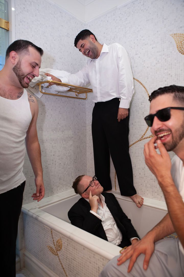 Celebration scene with guests playfully posing in a bathroom setting.