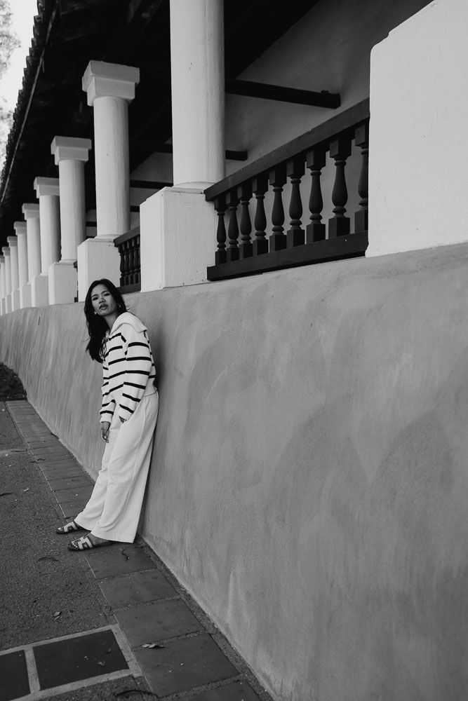 Architectural portrait with colonial style pillars and balustrades creating dramatic framing.