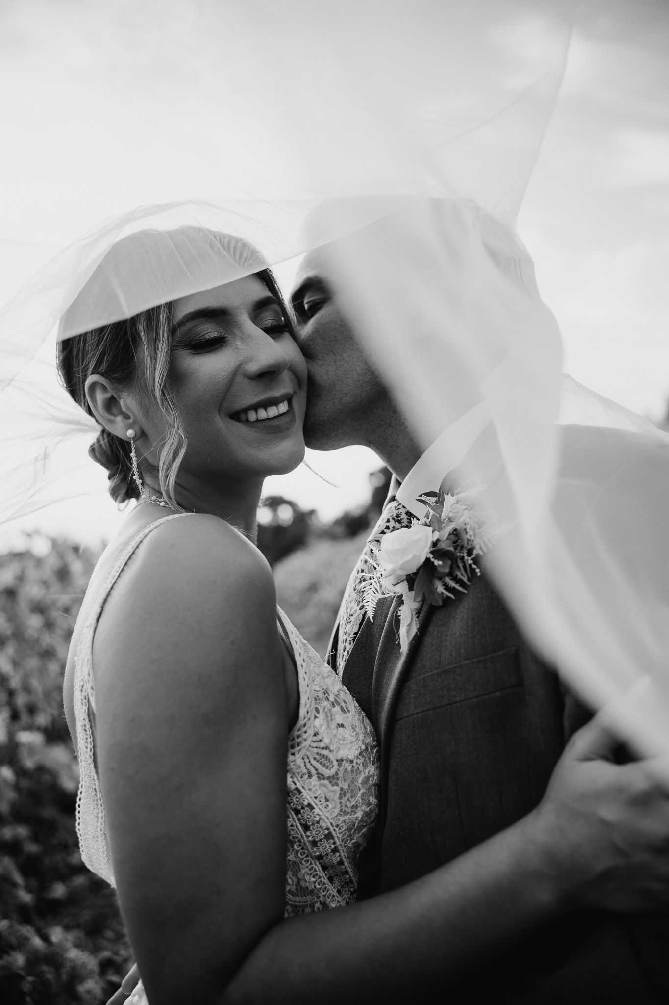 Black and white photos capturing intimate wedding moments under a flowing veil.