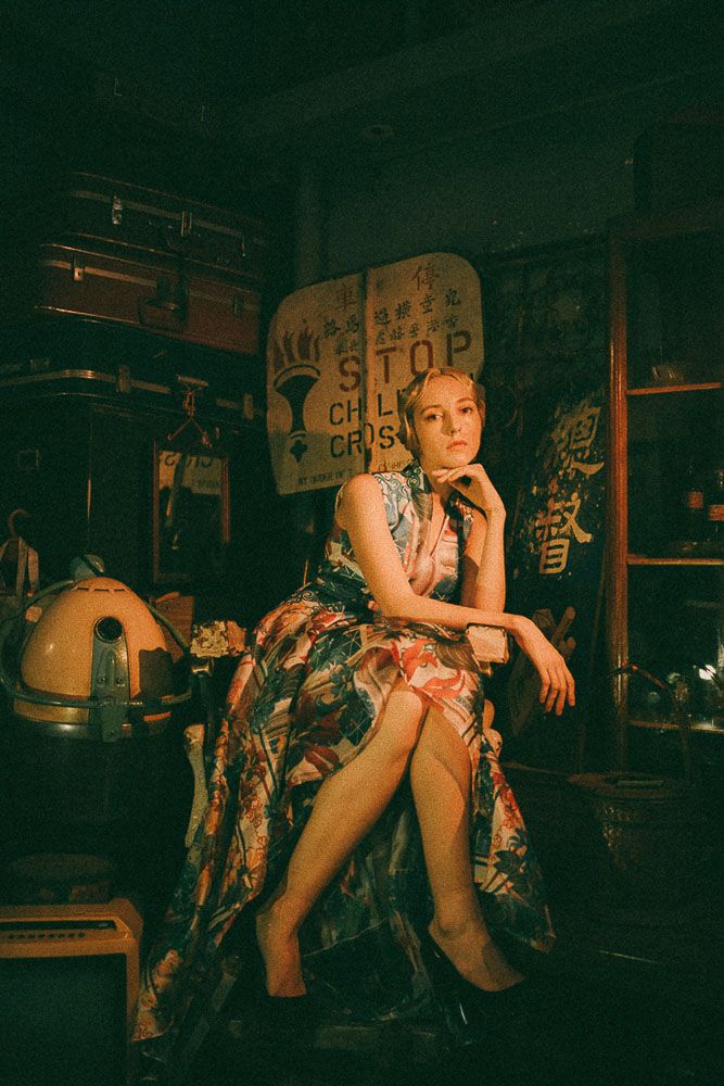 Retro-styled scene in Asian restaurant with floral dress and vintage decor.