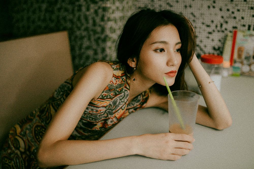 Casual cafe portrait with a glass drink and modern interior setting.