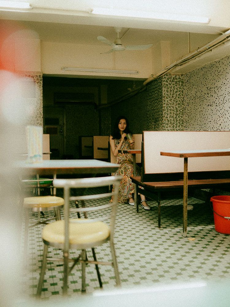 Vintage-toned photograph in a retro diner with checkered floors and mosaic walls.