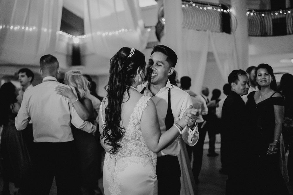 Black and white photo of a romantic dance moment at an elegantly decorated wedding reception.