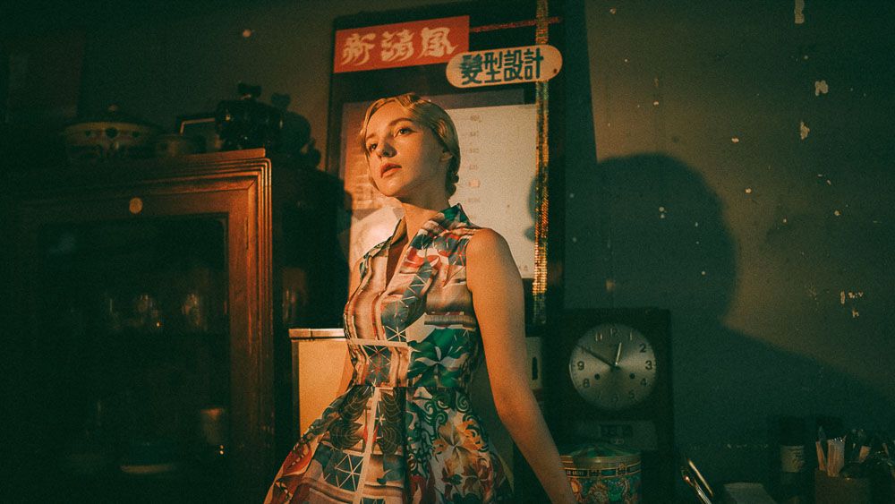 Moody portrait in front of Asian restaurant signage with retro aesthetic.