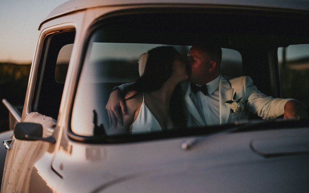 Romantic sunset moment captured through vintage truck window.
