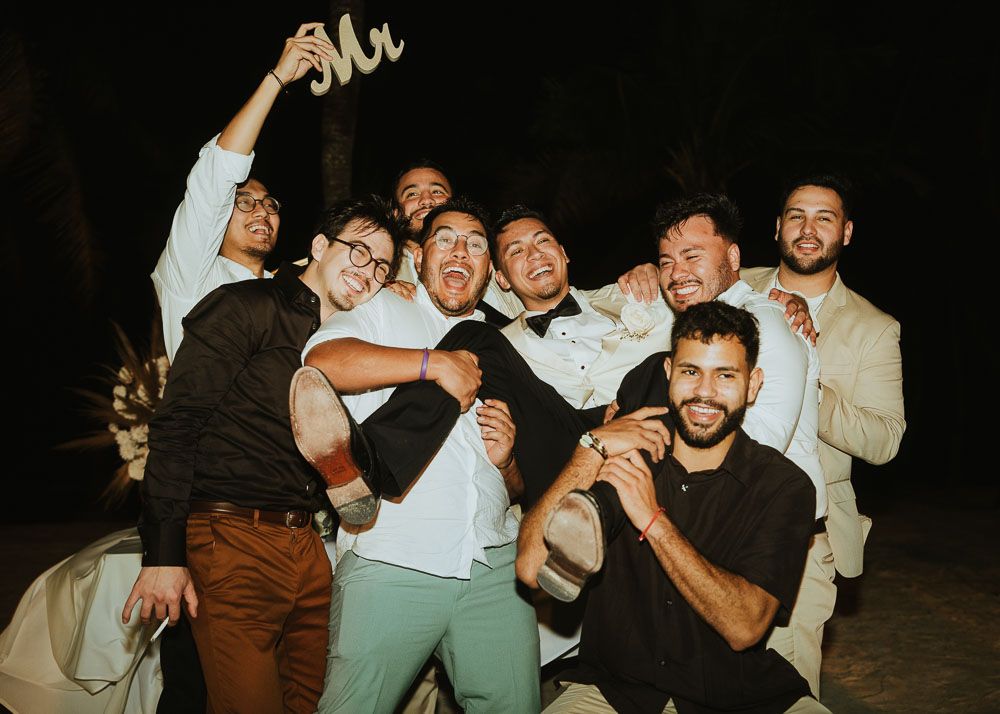 A group of friends posing together for a celebratory photo at night.