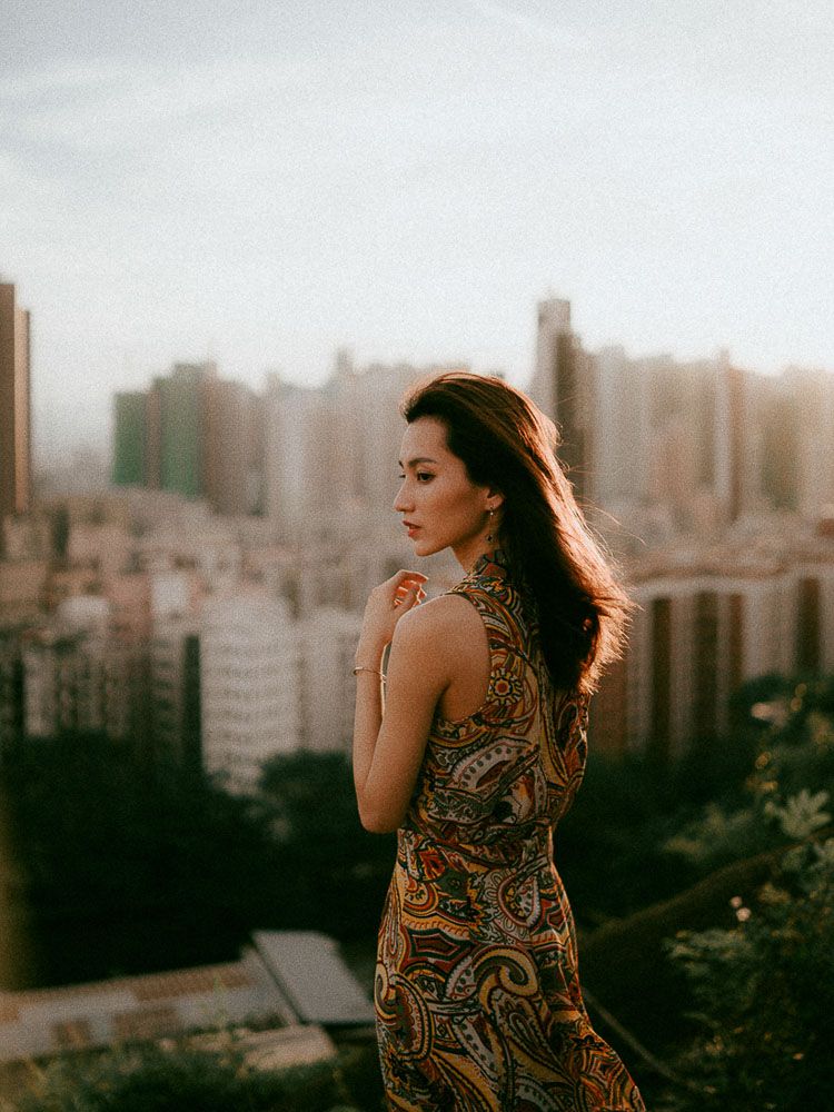 Stylish paisley dress photographed against an urban skyline at sunset.