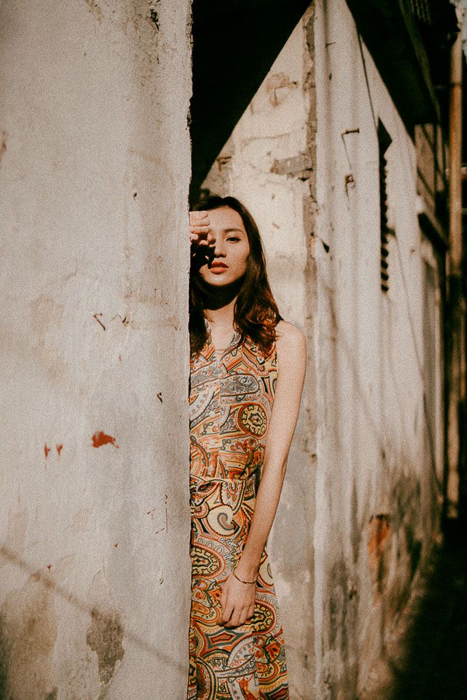 Dramatic fashion portrait series between white concrete pillars with high contrast lighting.