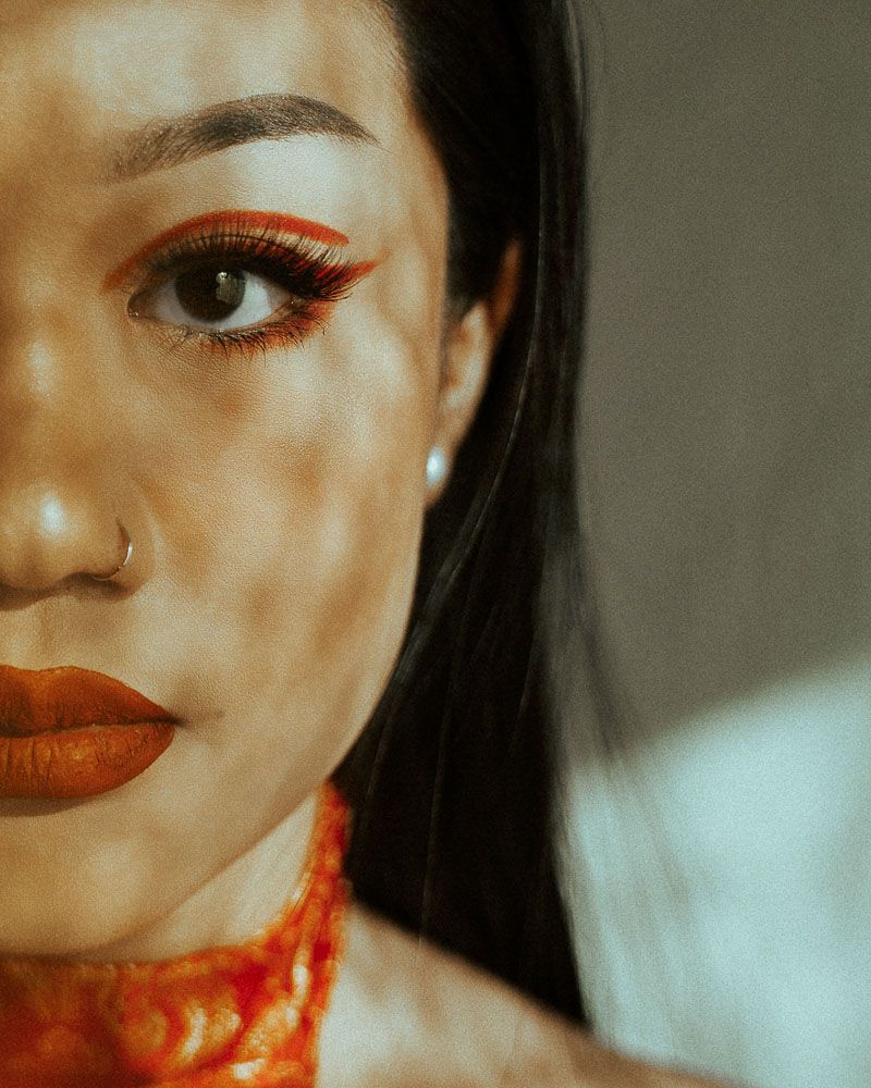 Artistic beauty shots featuring bold red lipstick and dramatic shadows in warm tones.