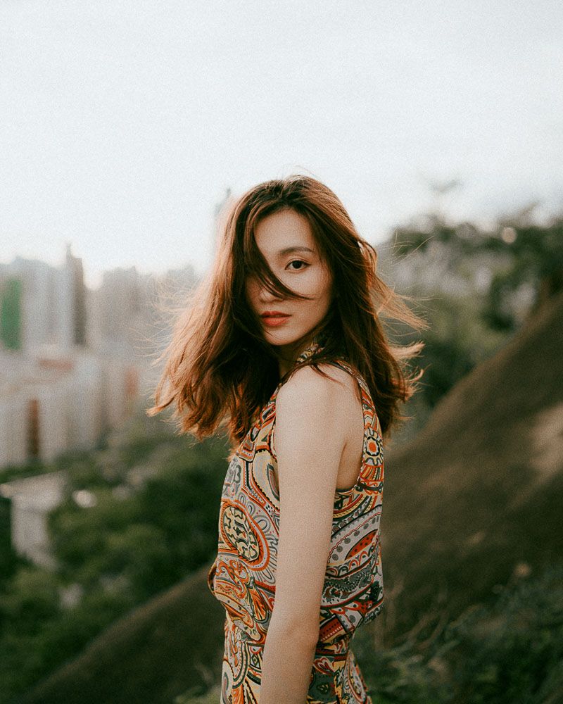 Fashion portraits featuring a patterned dress against city skyline backdrop.