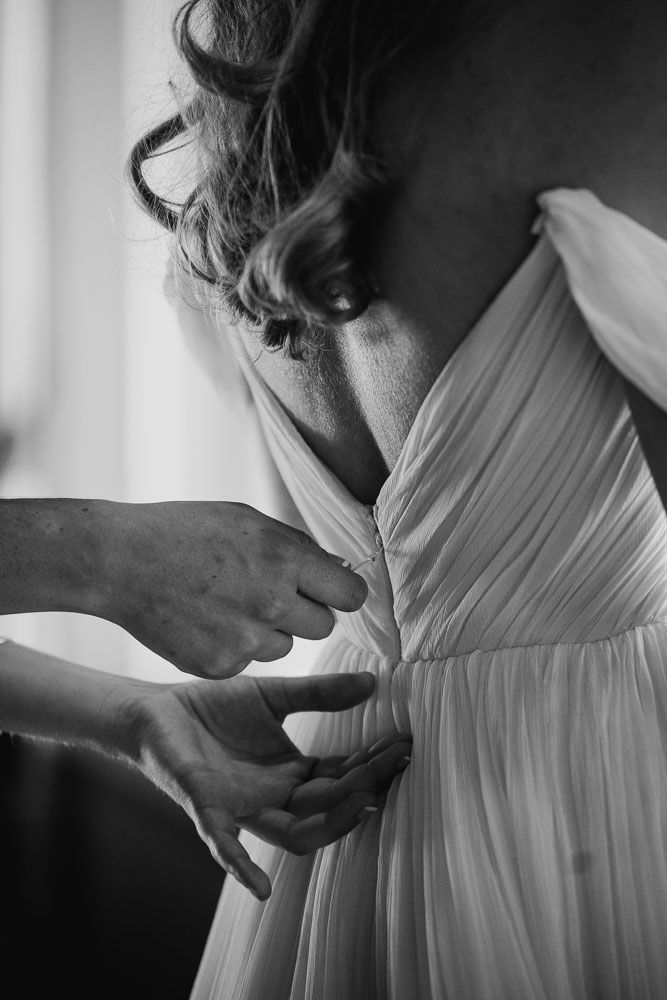 Close-up black and white shots of pleated white fabric being adjusted.