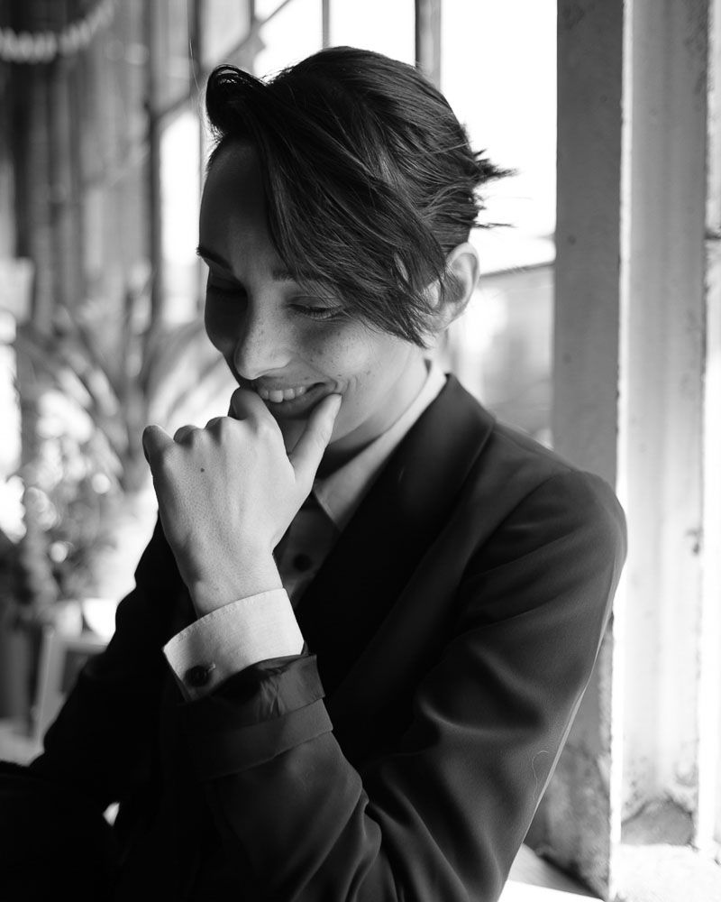Black and white portrait showing contemplative pose in formal attire.