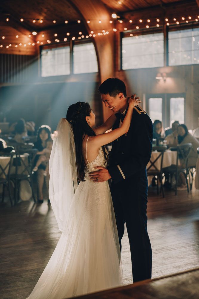Romantic first dance in venue with string lights and dreamy atmosphere.