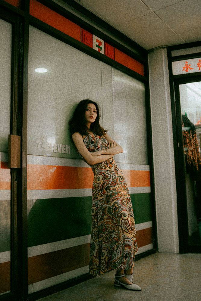 Moody interior hallway photoshoot showcasing a retro-styled dress with orange and white wall details.