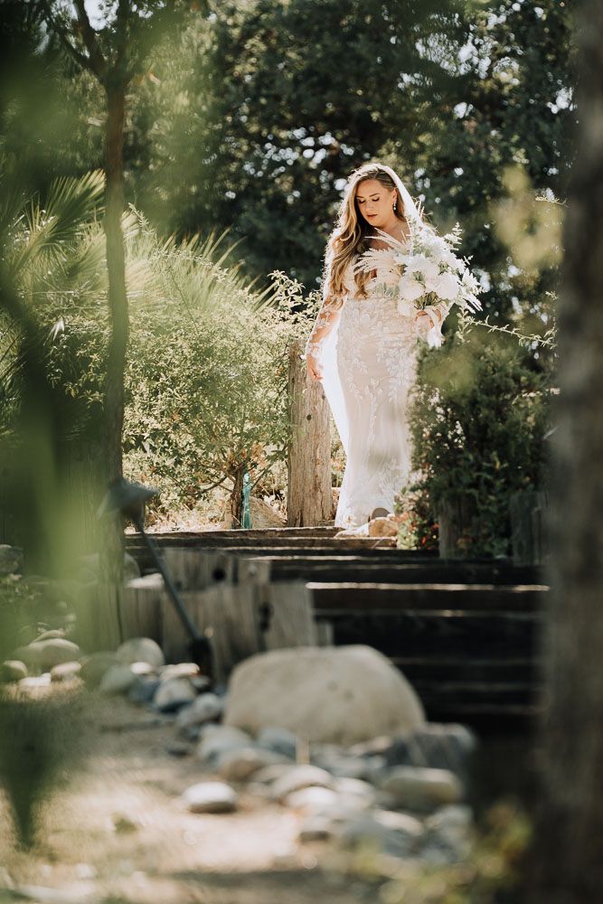 A dreamy bridal portrait on a wooden bridge surrounded by lush greenery and natural light.