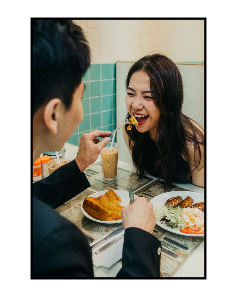 Couple sharing a meal together at a cafe with teal tiled walls.