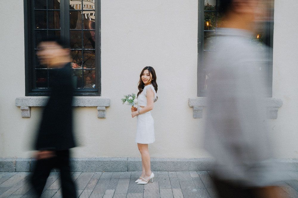 An artistic series of photos capturing pedestrian motion blur against a white urban wall.