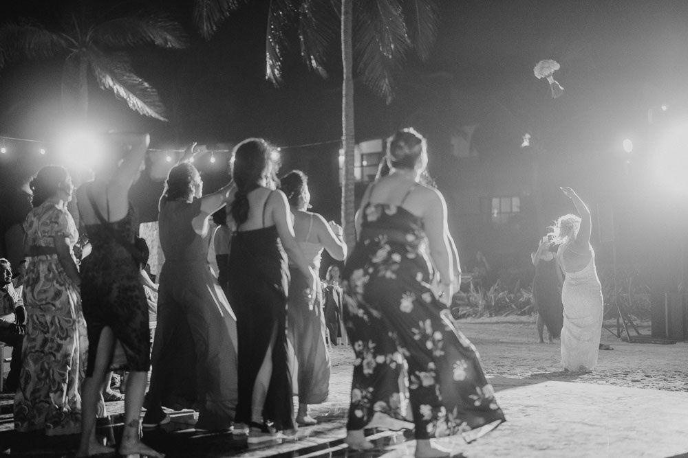 People dancing at a nighttime outdoor celebration with atmospheric lighting.