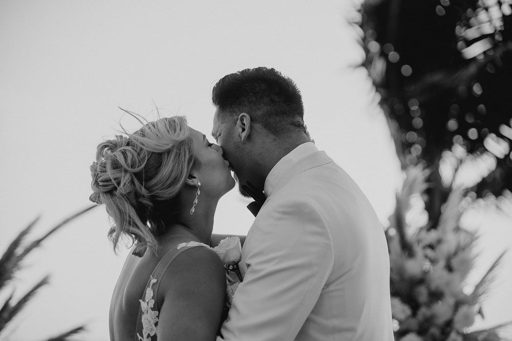 Black and white photo of a romantic moment between a couple during their wedding celebration.