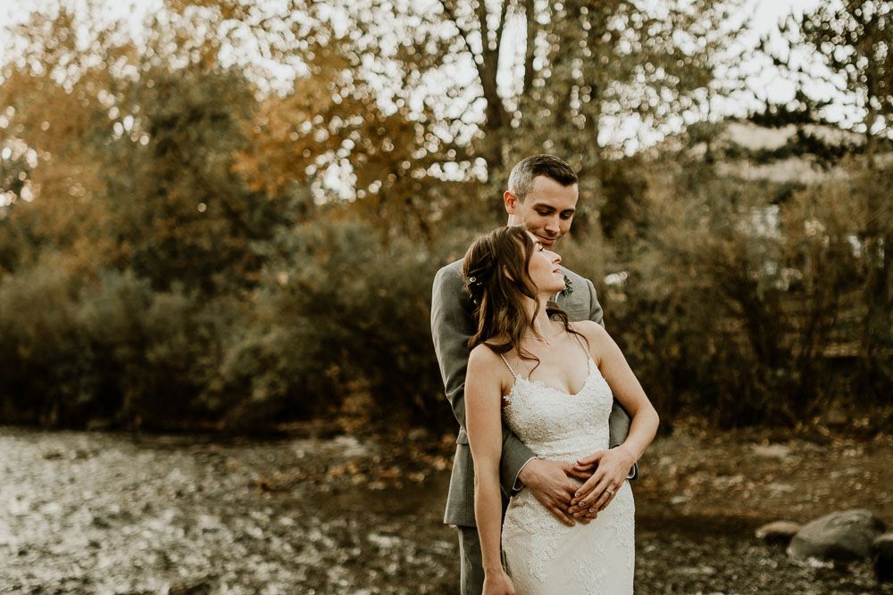 An elegant outdoor wedding photoshoot set against a natural autumn backdrop with fall foliage.