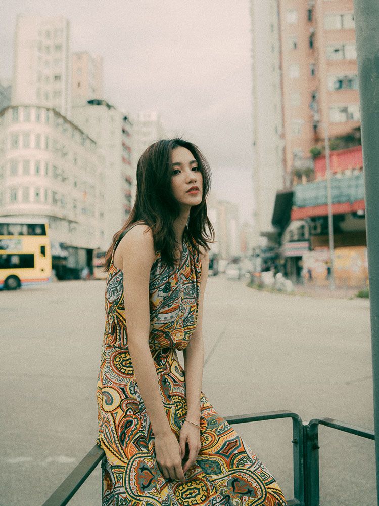 Street style photography with a patterned dress against modern city architecture and buildings.