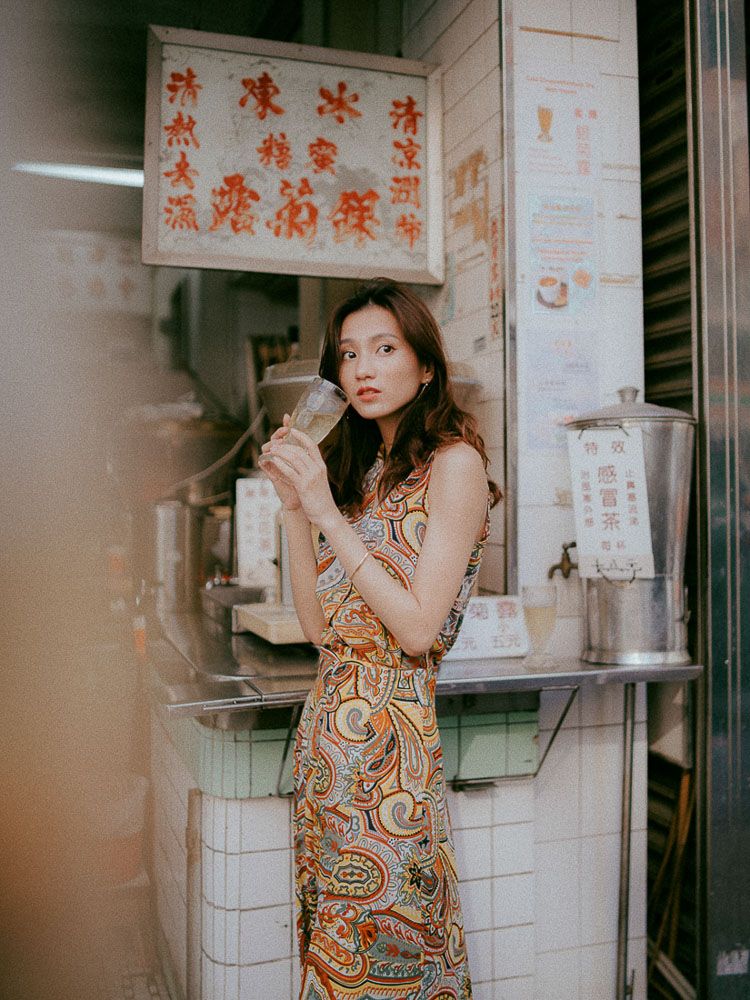 Retro-styled fashion photo at an Asian street vendor with Chinese characters on signage.