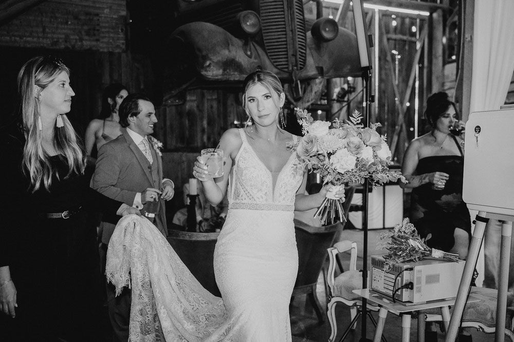 Wedding guests socializing and celebrating at an indoor reception venue in black and white.