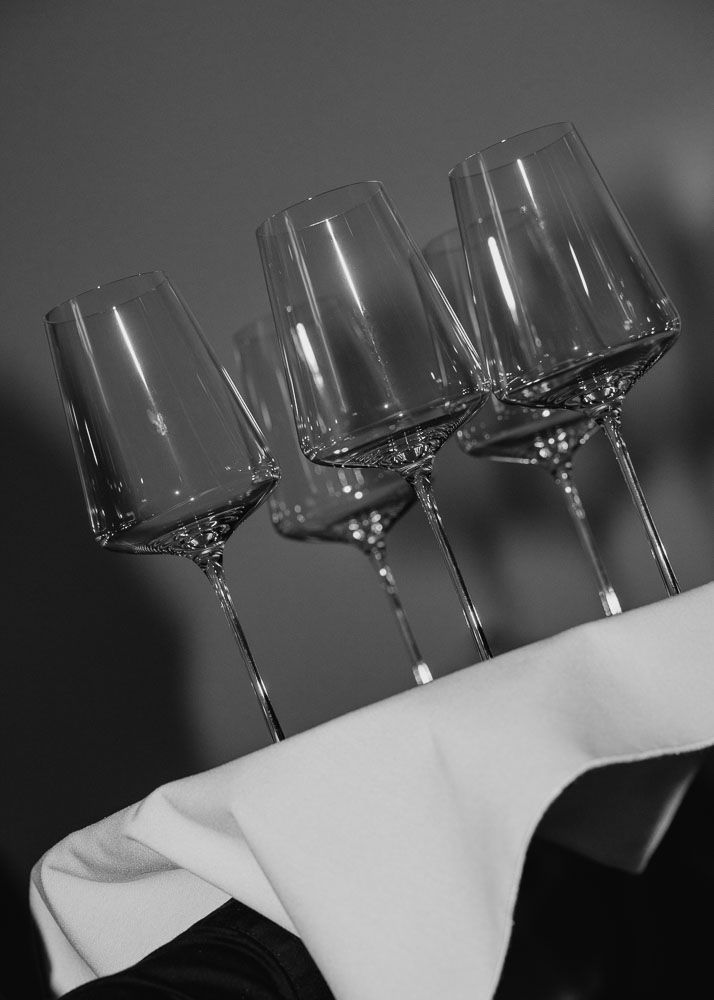 Three elegant wine glasses arranged in a row against a dark background.