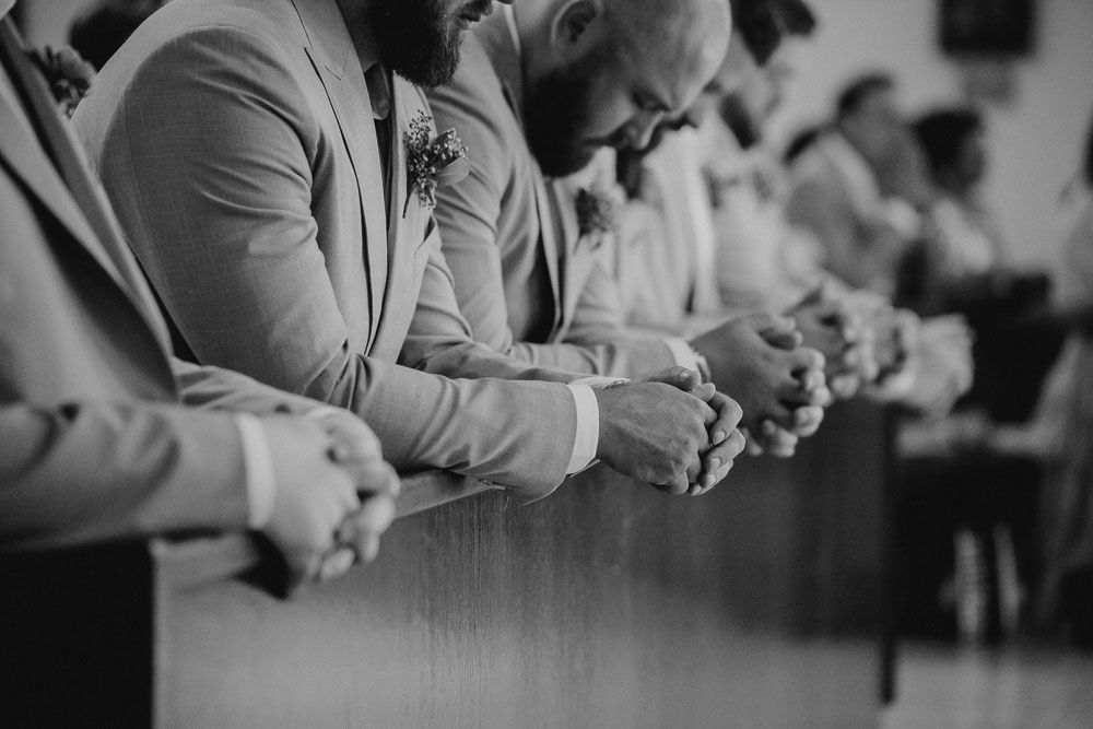 Hands and small gestures along the ceremony pew