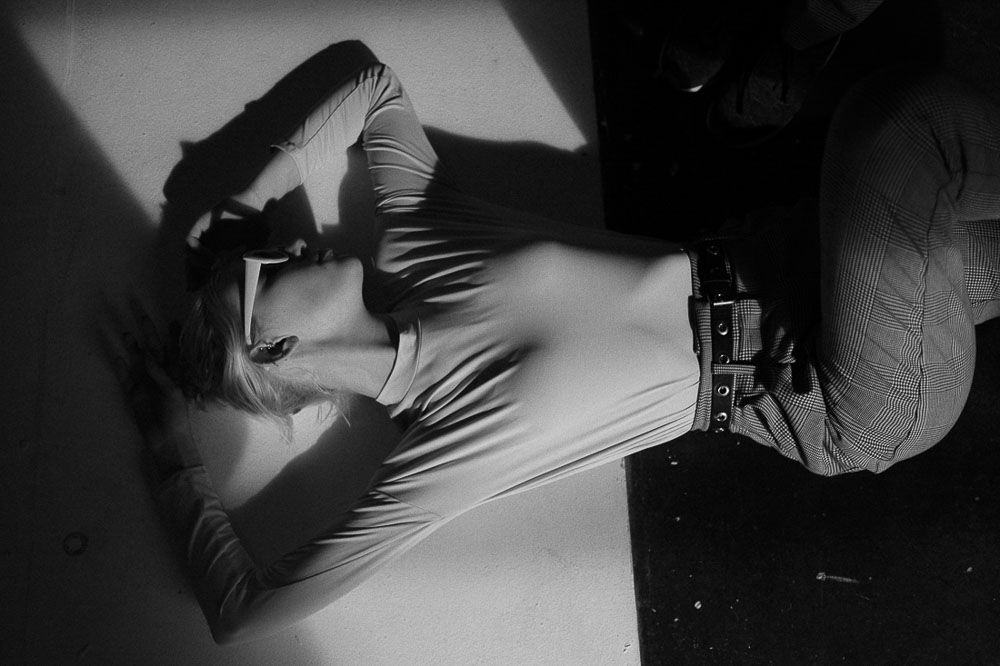Artistic black and white maternity photoshoot with dramatic lighting and shadows.