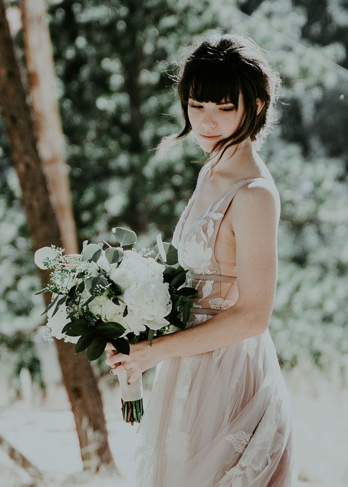 Ethereal bridal portraits in a dreamy forest setting with white floral bouquet.
