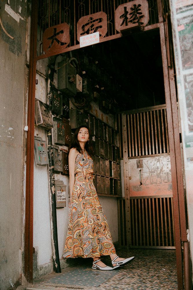 Urban fashion shoot in a grungy alleyway with Chinese text and traditional architecture elements.