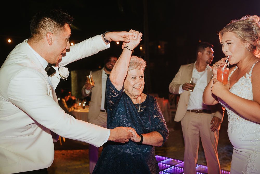 Dancing with older guest during lively wedding reception celebration.