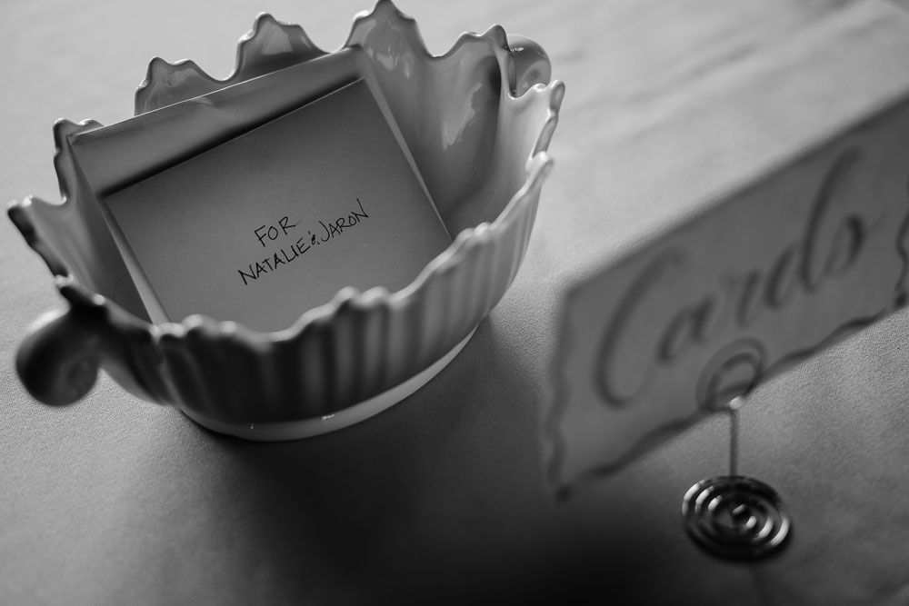 Artistic black and white photo of a decorative dish holder with cards and place settings.
