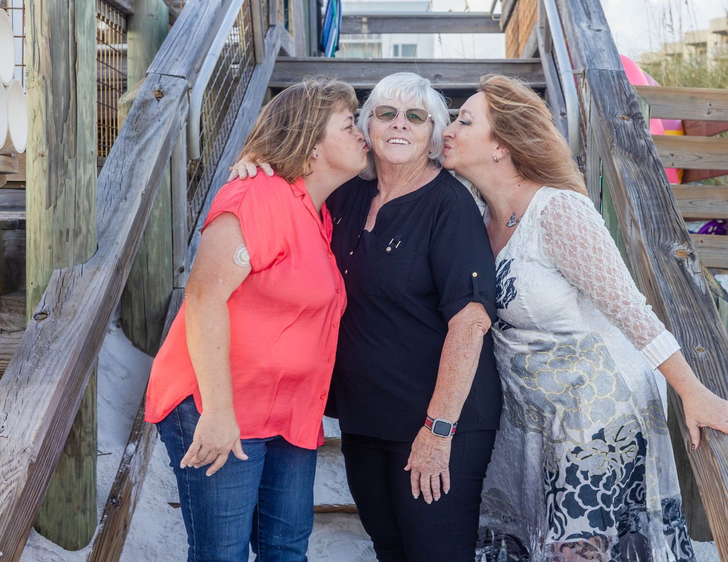 Group enjoying a casual gathering on a wooden deck by the water.