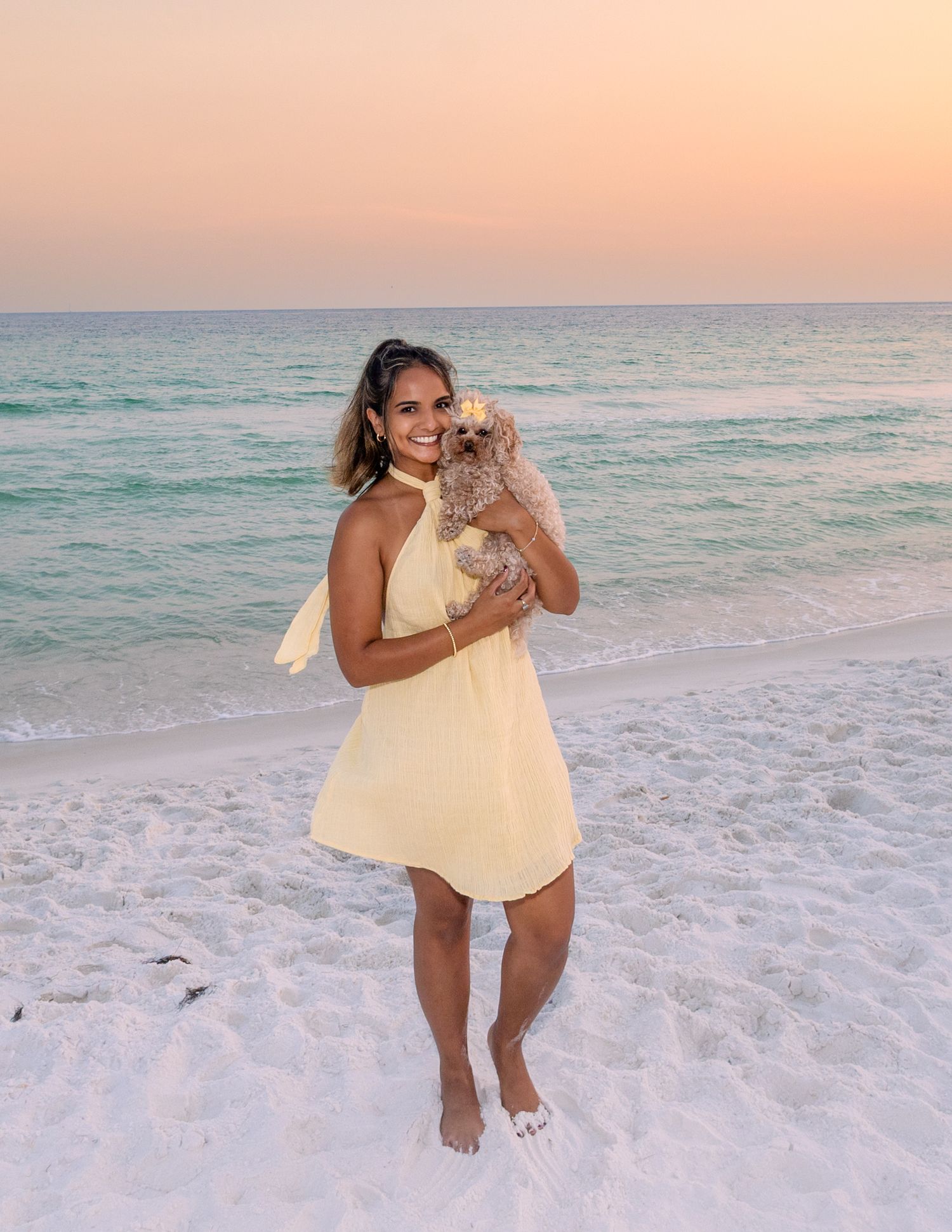 Playful moments captured on a white sandy beach during sunset with turquoise waters in background.