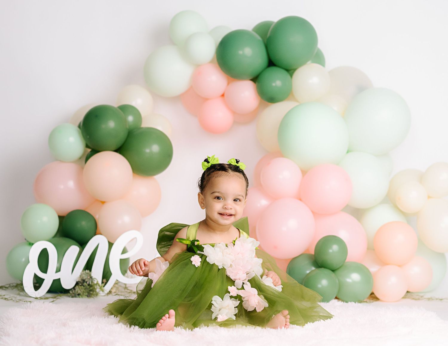 Birthday setup with organic balloon arch in mint green and peach colors.