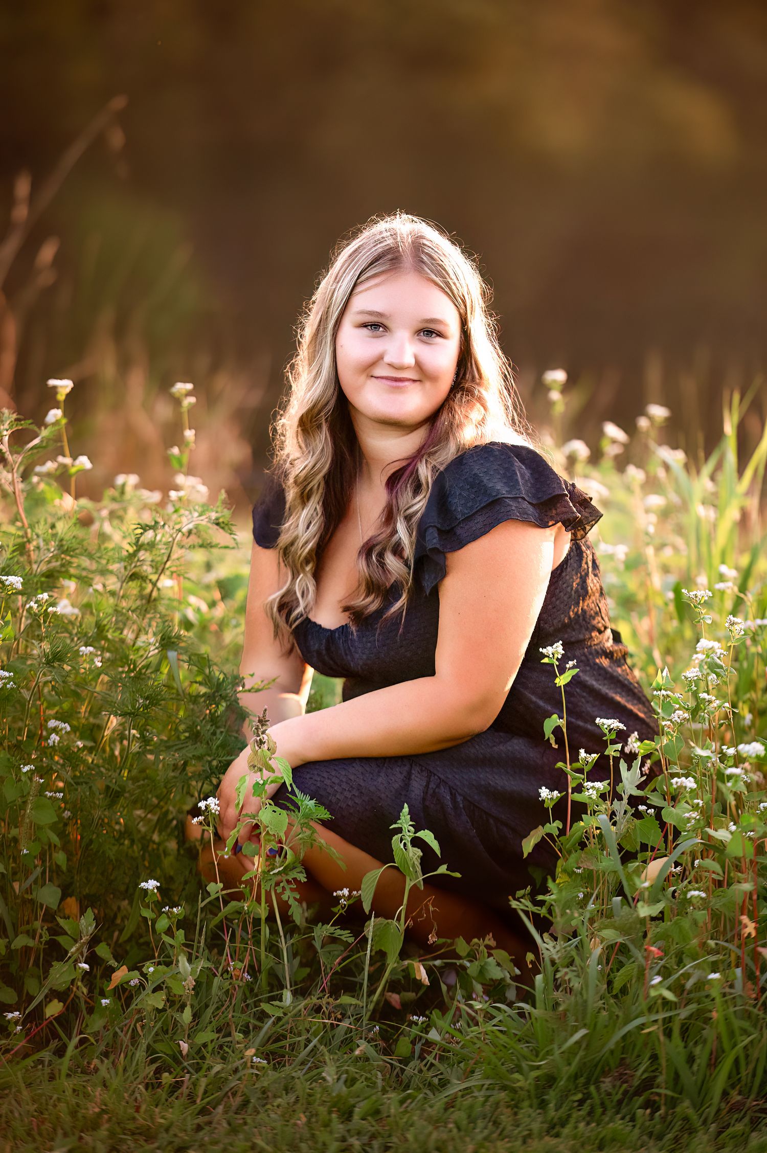 Portrait session in blooming wildflower meadow during golden hour.