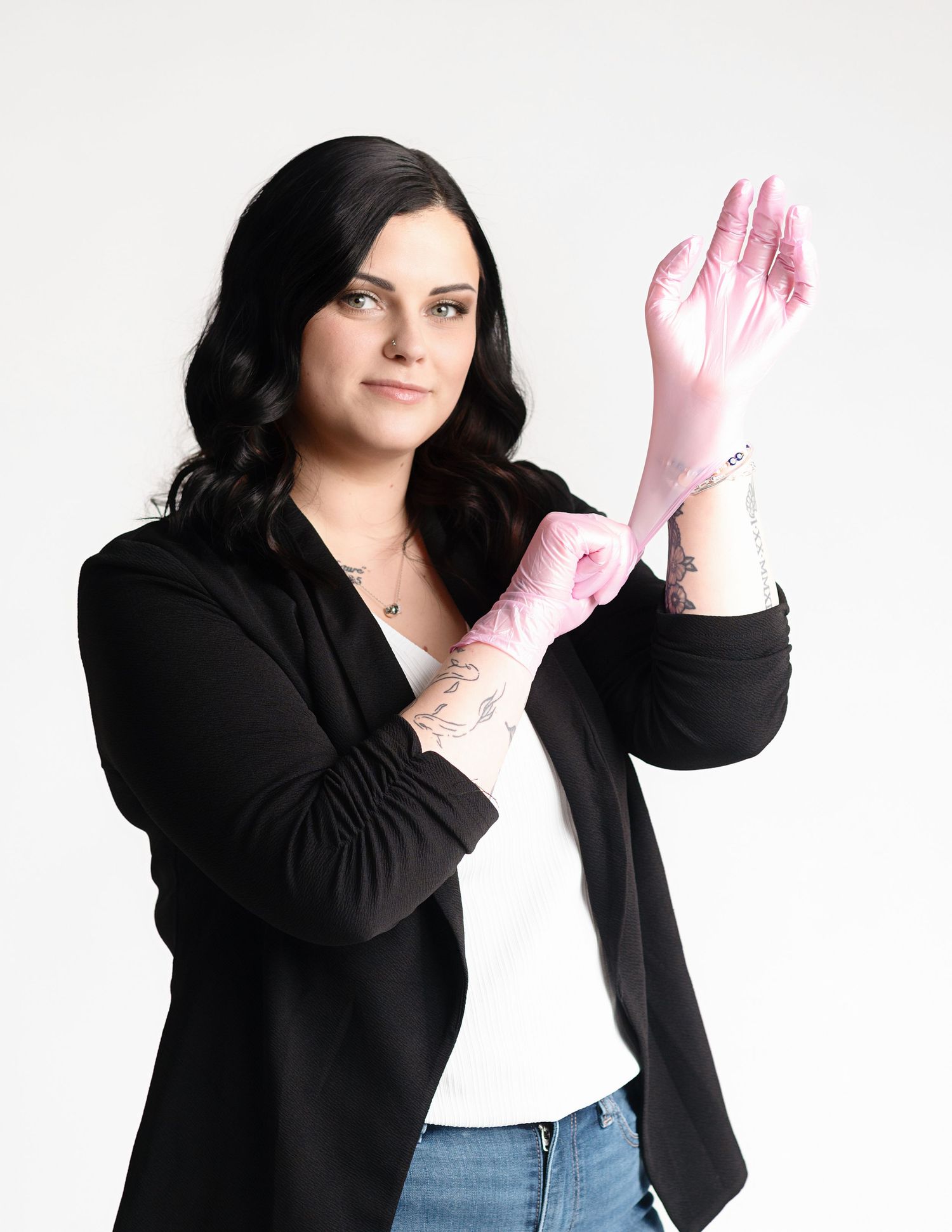 Woman in black blazer striking different poses with pink gloves against white background.