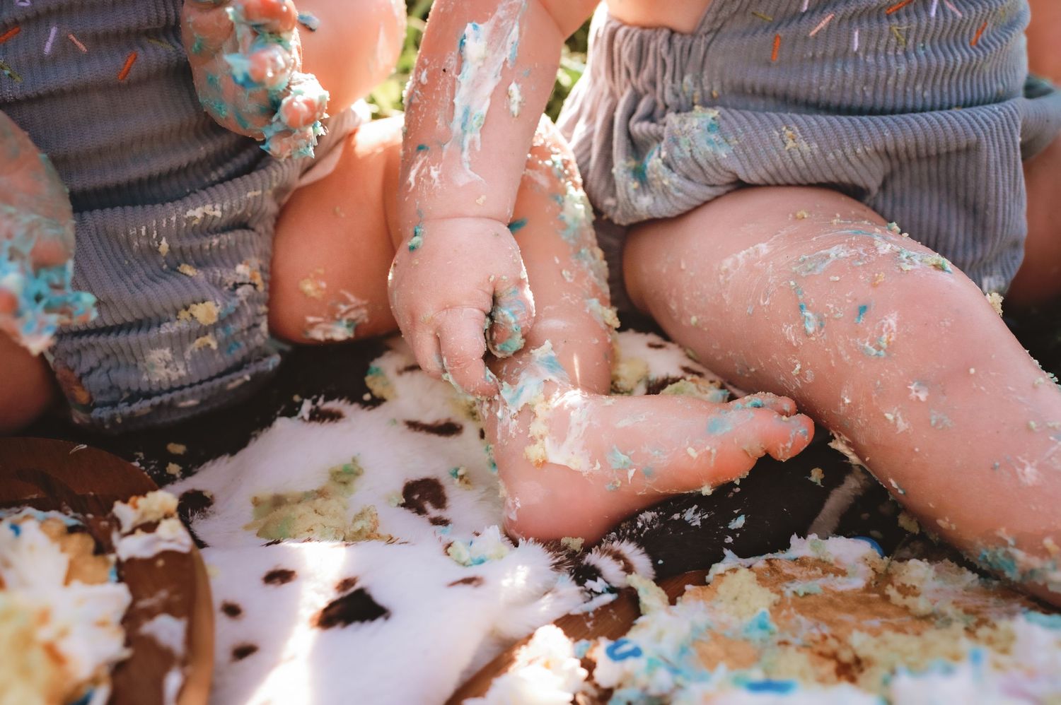 Close-up of legs covered in colorful cake frosting and sprinkles.