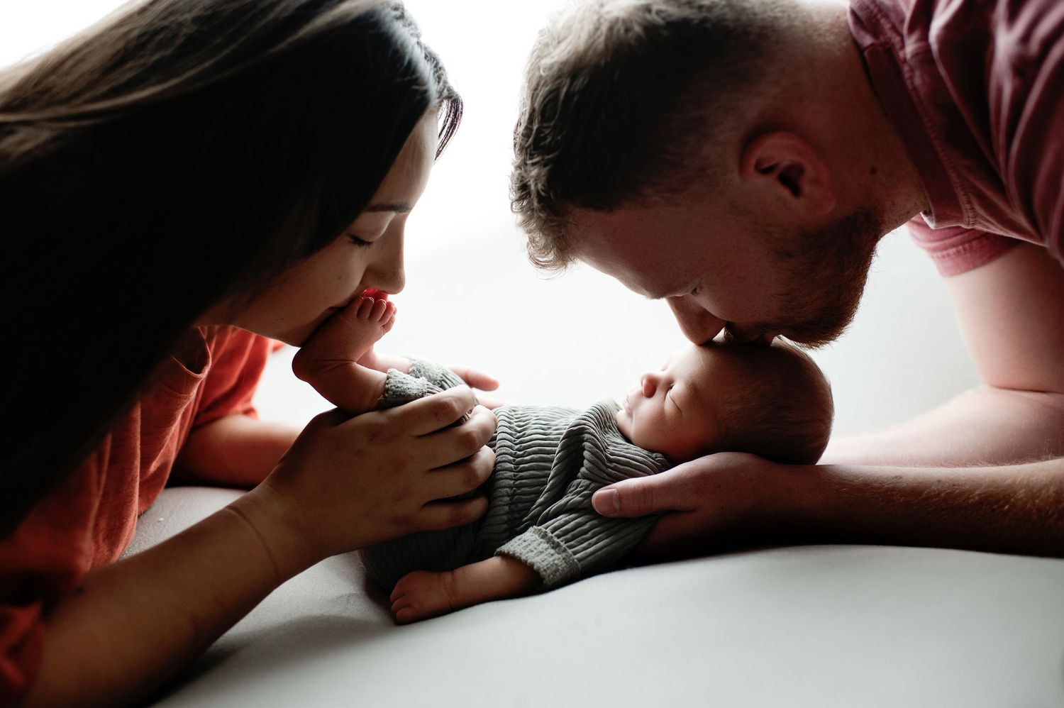 Silhouetted figures in intimate close-up poses against light background.