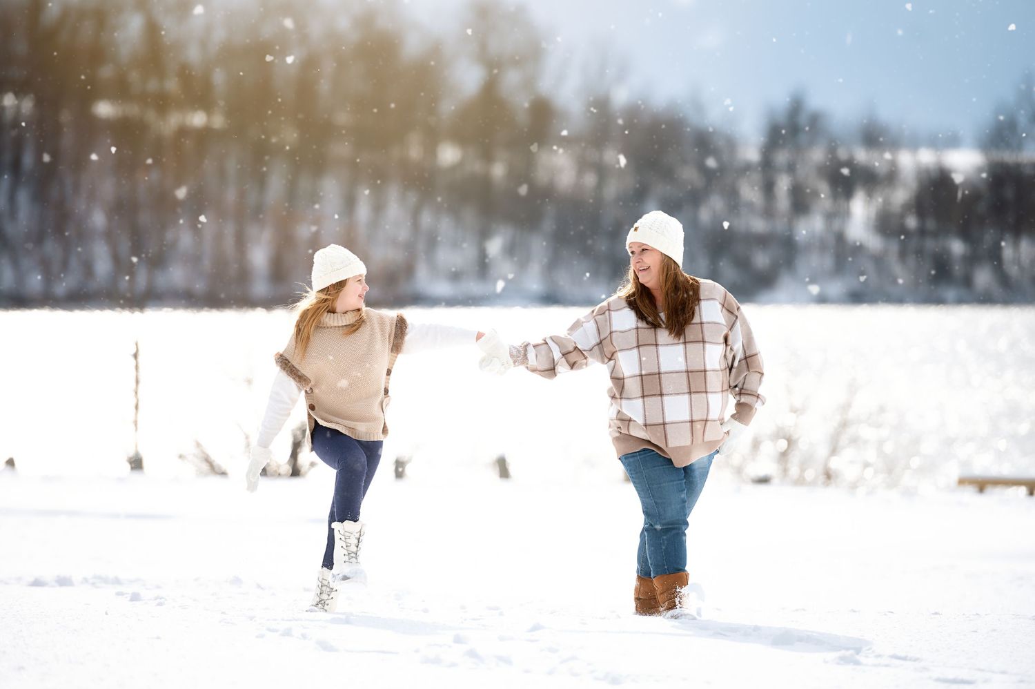 Winter landscape scene with snow falling across a wide open field.