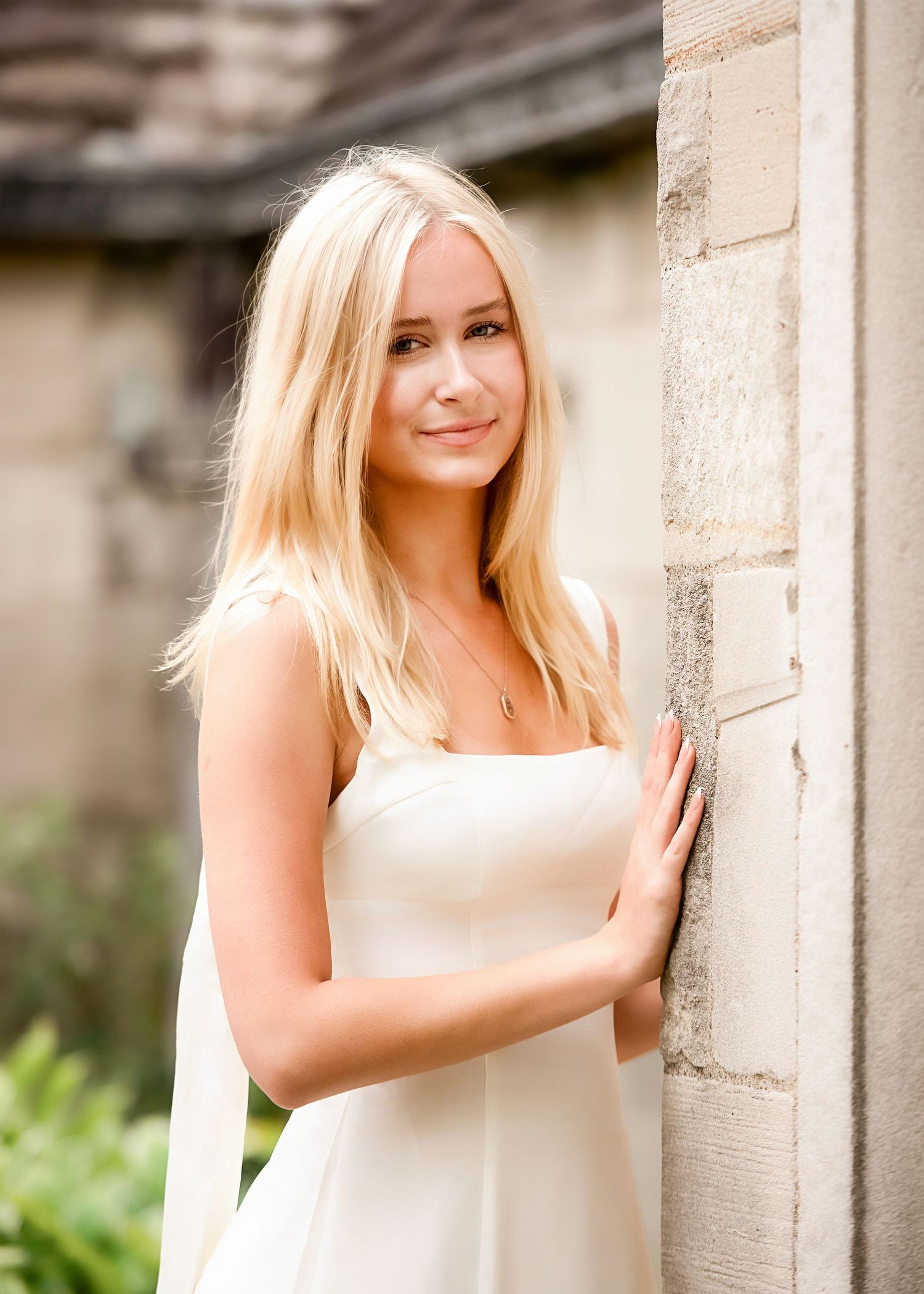 Fashion portraits featuring a white top against stone columns and architectural details.