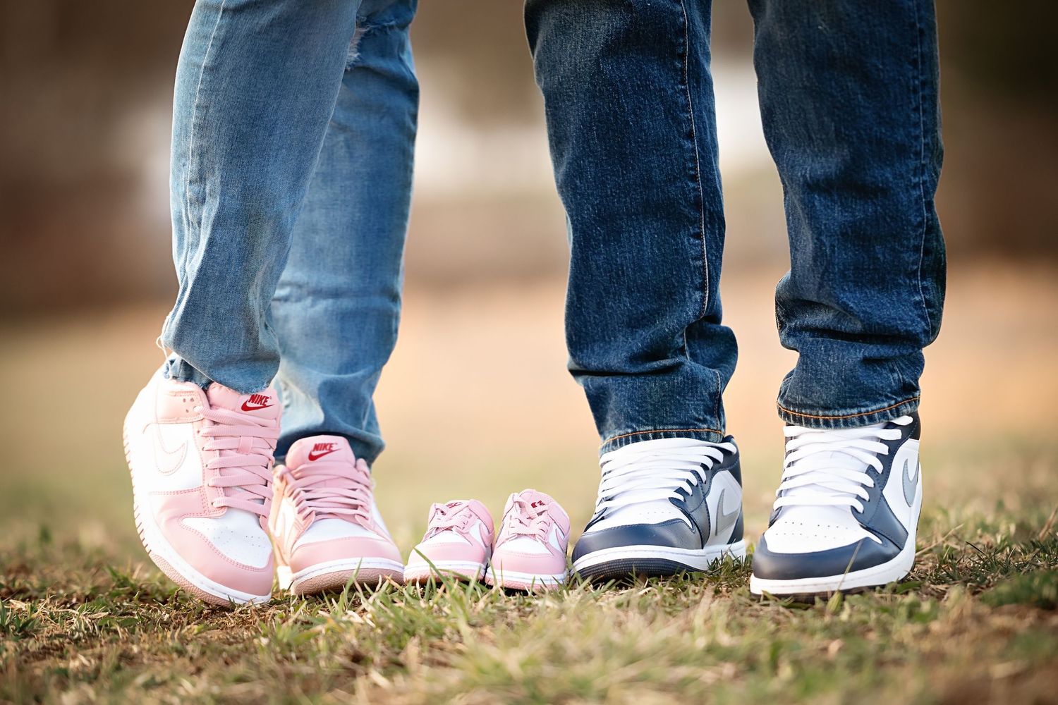 Close-up of feet showing pink and gray sneakers on grass.