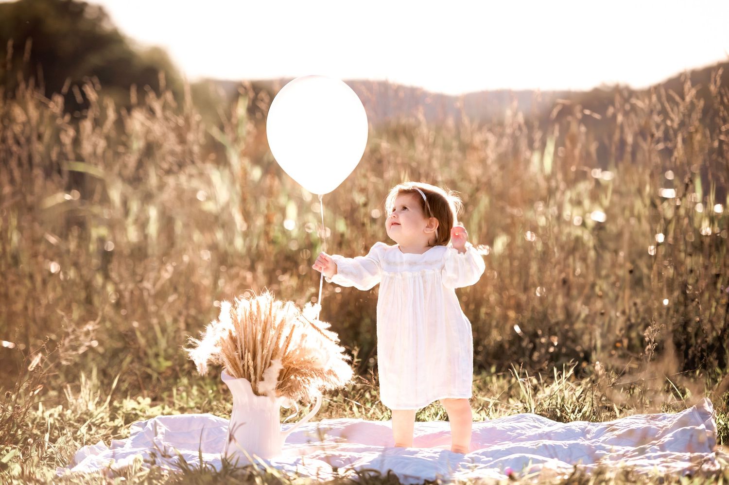 A series of dreamy outdoor photos in a field at sunset with warm golden lighting and a whimsical atmosphere.