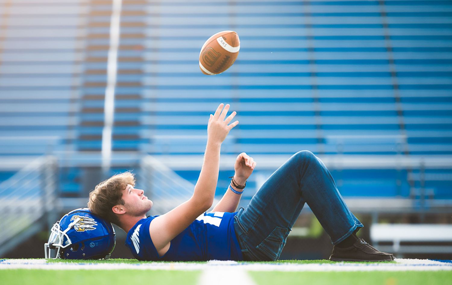 Football spiraling through the air against blue sky during game play.