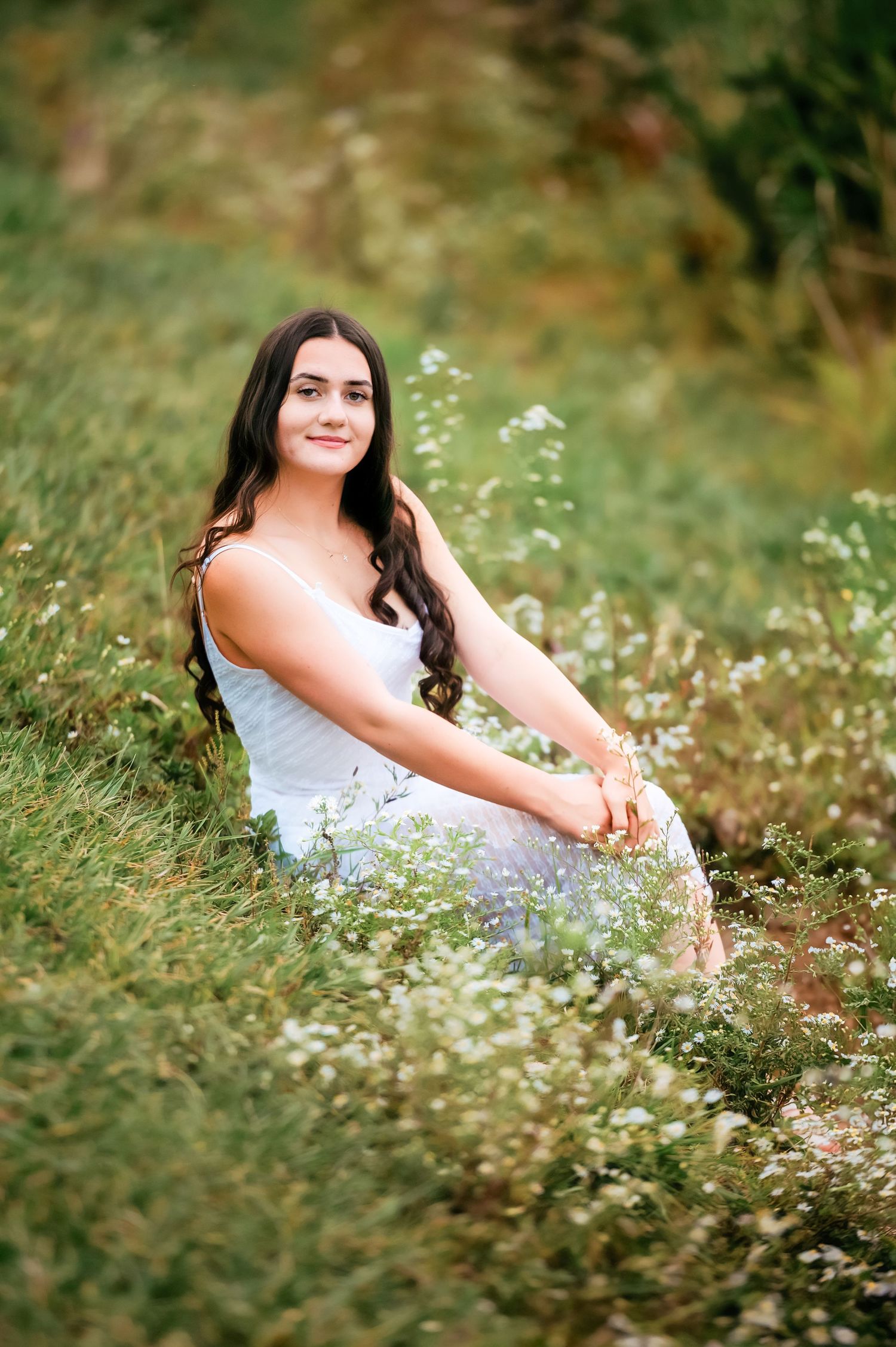 White wildflowers create a dreamy setting for an outdoor portrait in a meadow.